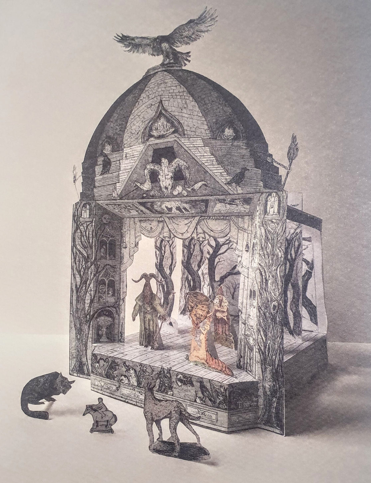 A three-dimensional paper toy theatre featuring a gothic-style magical show scene, with a bird perched on the roof, and various magical characters, perhaps sorcerers or witches, on the stage. Further small figures and animals stand in the foreground in front of the theatre.